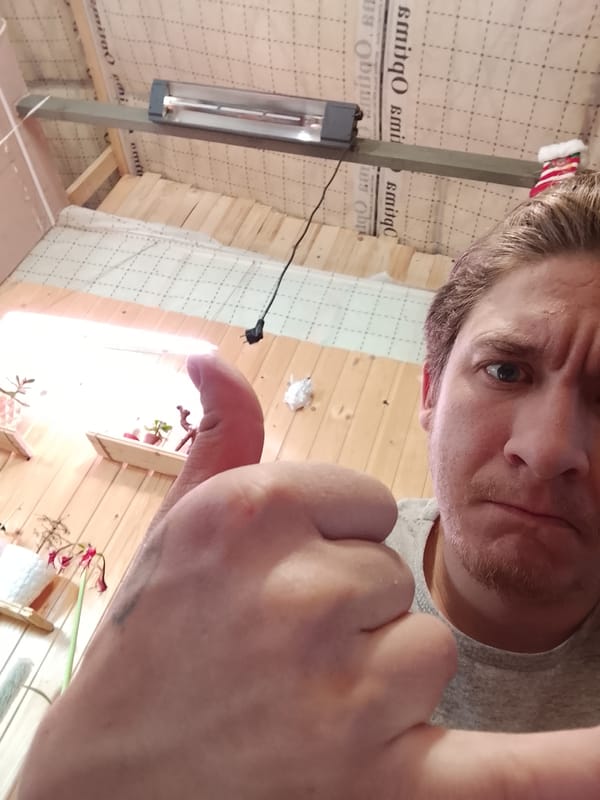 Man poses with thumbs-up in Russian workshop setting