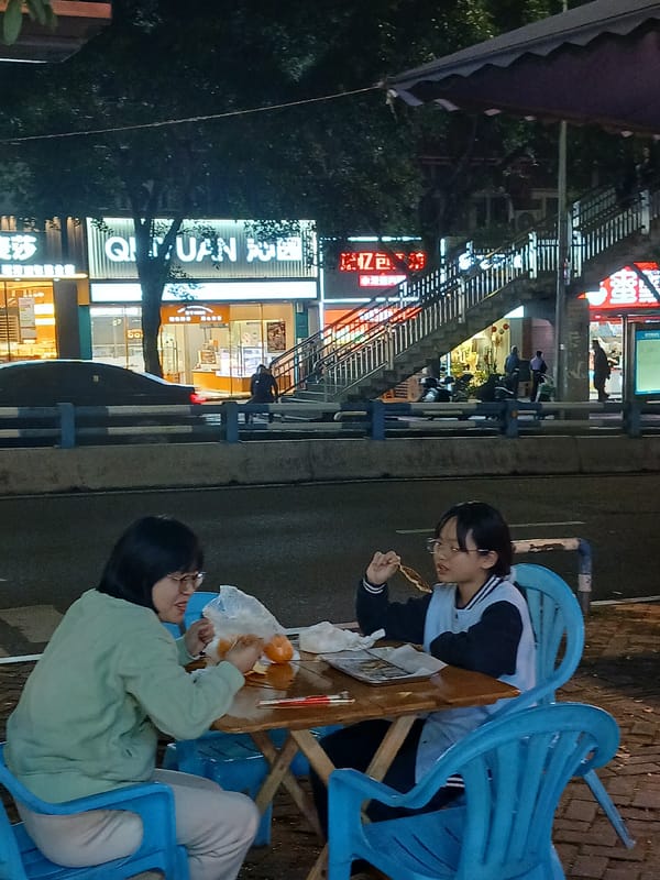 Young women share street food meal in Shapingba District