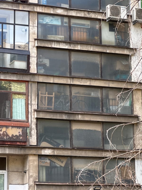 Concrete building facade in Ruse, with a traffic note