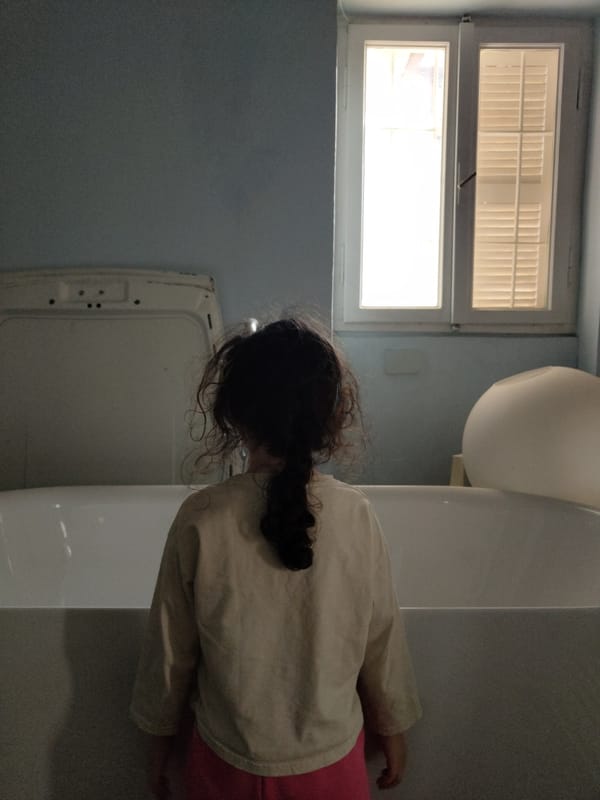 Young person observed in bathroom interior near toilet and sink