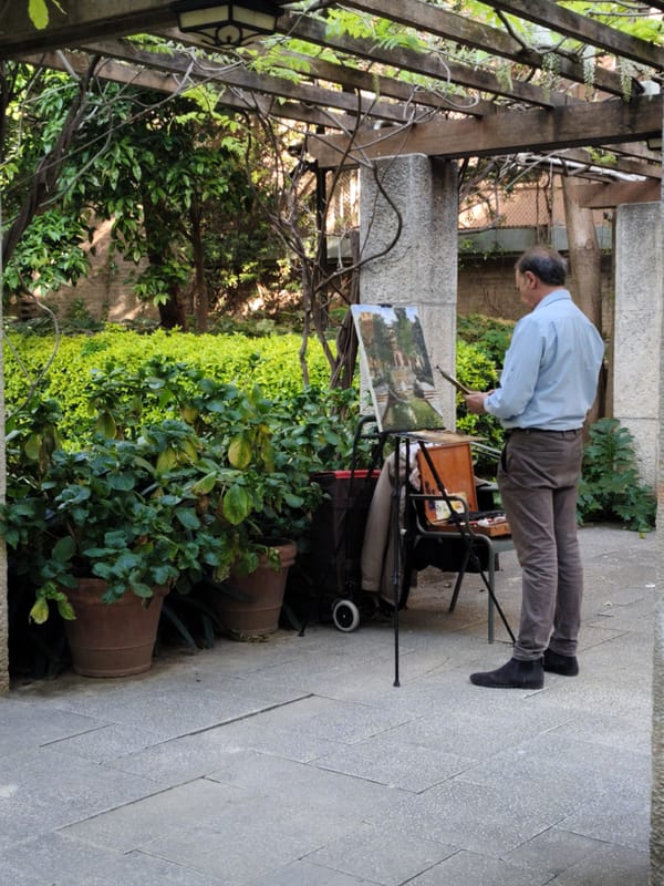 Artist paints in Barcelona garden as children watch nearby
