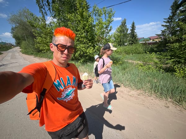 Man in orange enjoys ice cream during morning walk in Chaikovsky