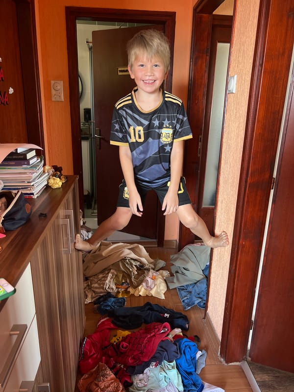 Boy in soccer jersey poses in doorway in Podgorica