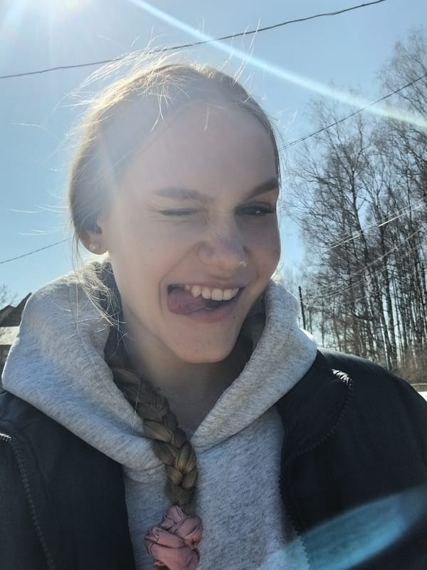 Woman takes spring morning selfies among blooming flowers in Russian forest