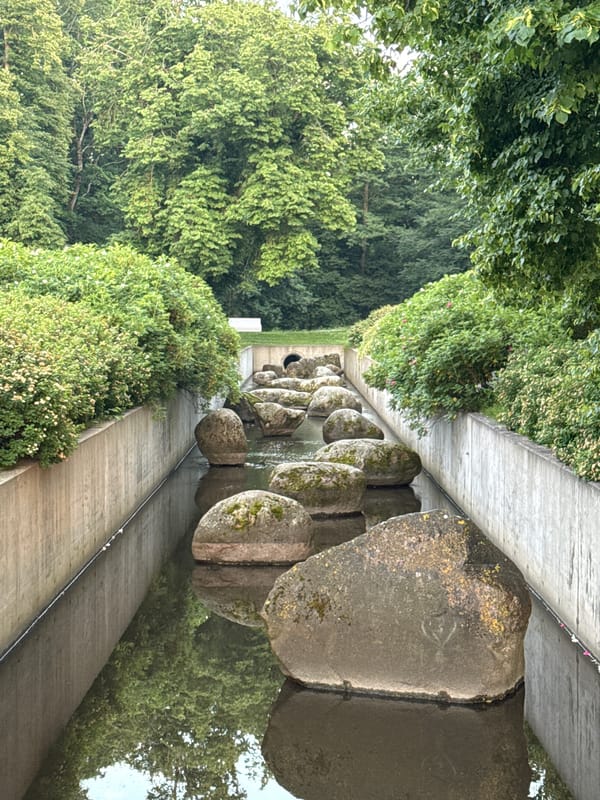 Stone-lined canal with lush greenery in Tallinn
