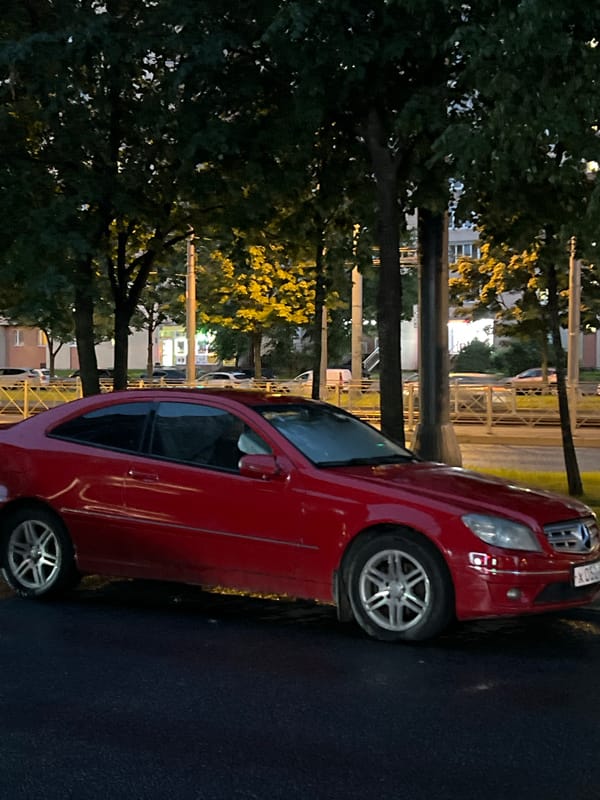 Cars parked roadside in Russia at dusk after rain