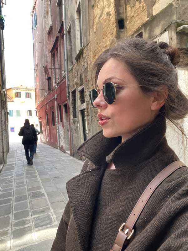 Tourist photographed on narrow Venice street amid historic architecture