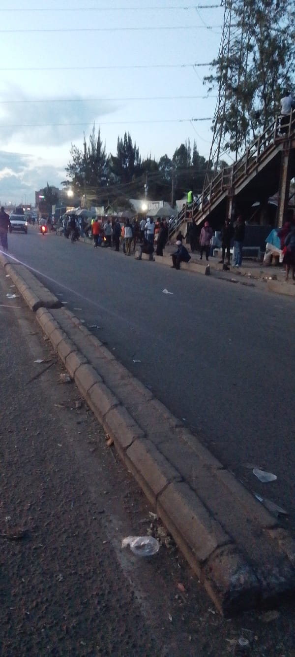 Crowd gathers along debris-scattered roadside in Nairobi