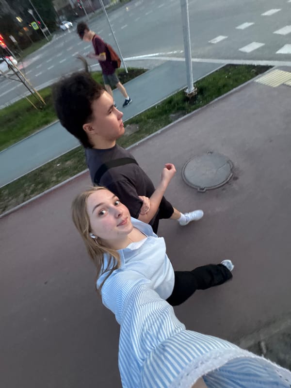 Two people photographed on sidewalk near bridge in Perm