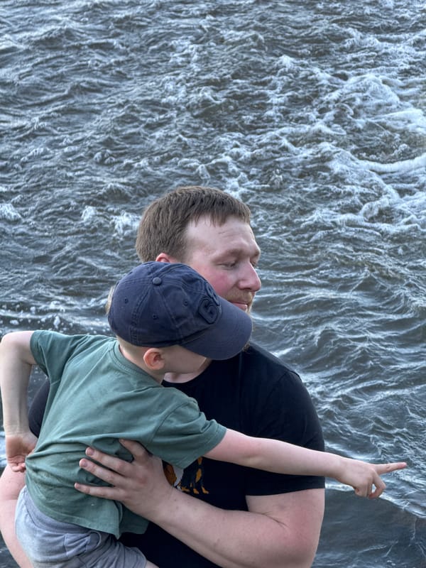 Father and child enjoy playful moment at Russian waterfall