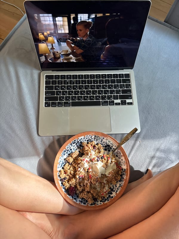 Woman enjoys breakfast in bed with laptop in Chaikovsky