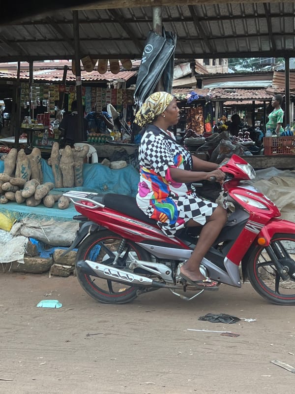 Woman on motorcycle observed at local market scene