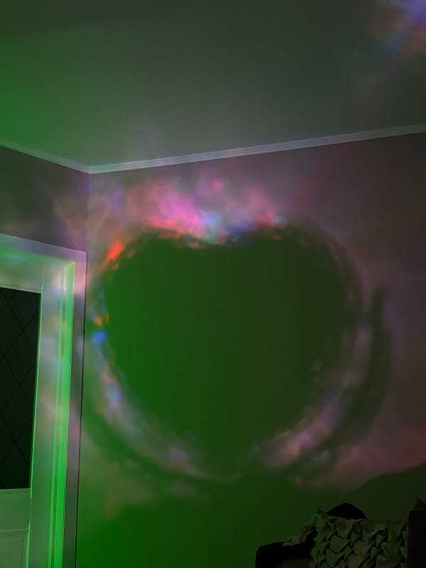 Person documents decorative objects and colorful lighting indoors