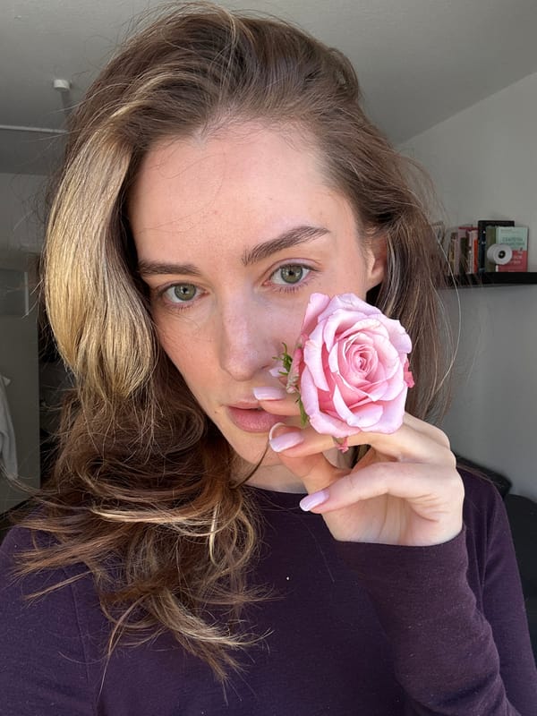 Woman poses with pink rose in Kiel portrait session