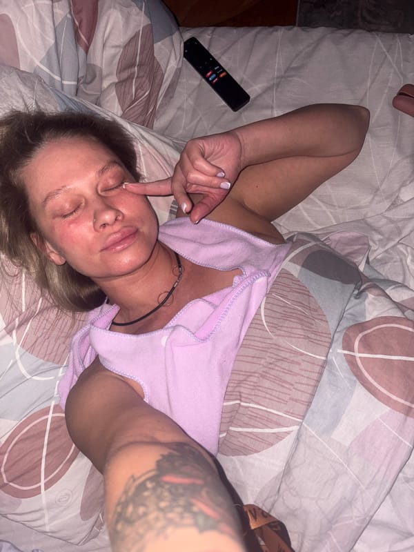 Woman resting on bed touches eyelid in Perm