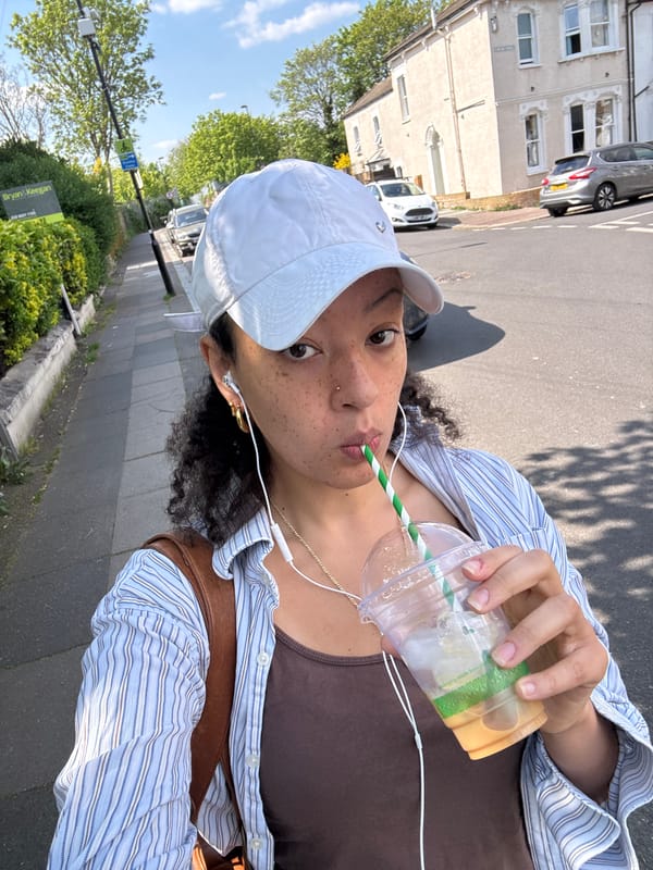 Person enjoys iced coffee on sunny afternoon in London
