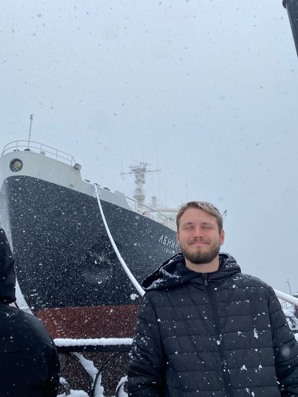Tourist photographs Lenin Icebreaker museum in snowy Murmansk