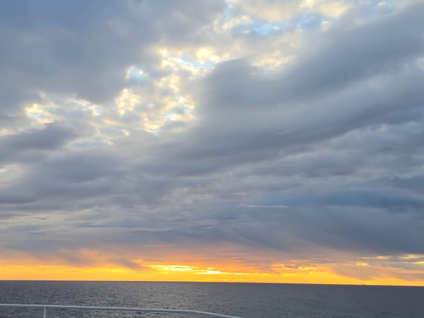 Golden sunset breaks through gray clouds over Norwegian coast