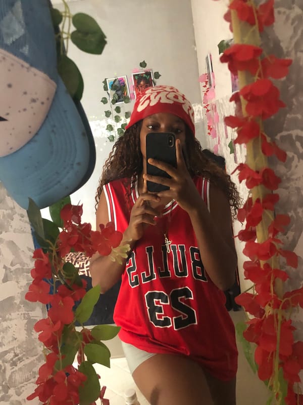 Person takes mirror selfie in red jersey in Kashere