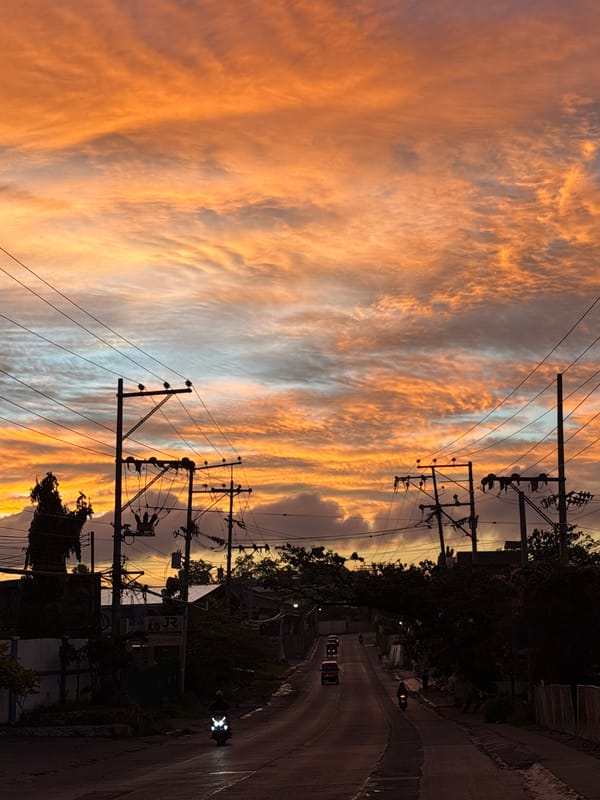 Davao City streets glow under a fiery evening sky