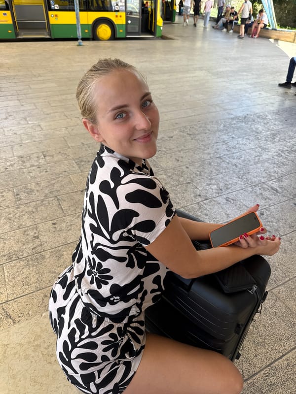 Young woman travels through Pula, Croatia with suitcase