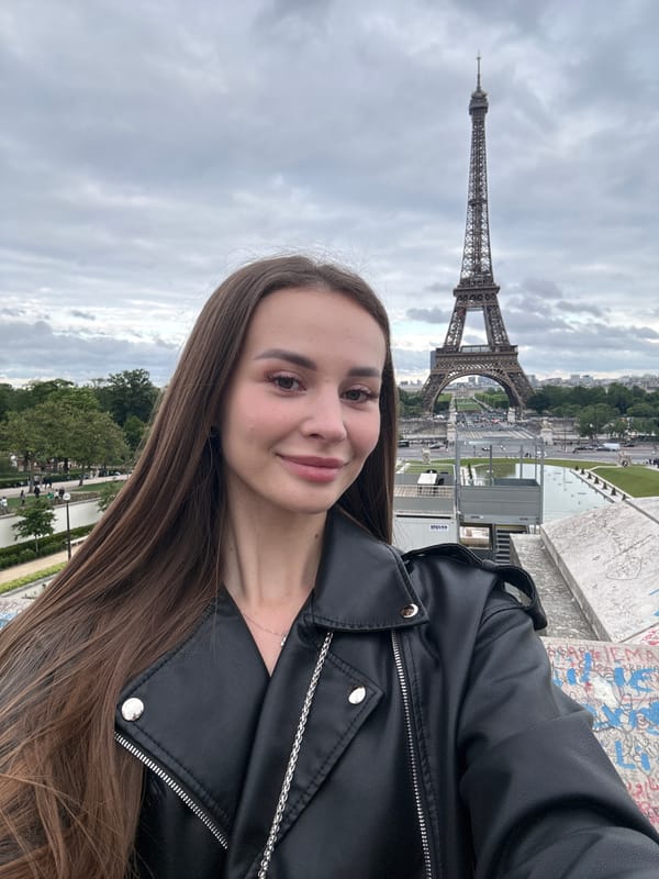 Woman poses for photo at Eiffel Tower in Paris