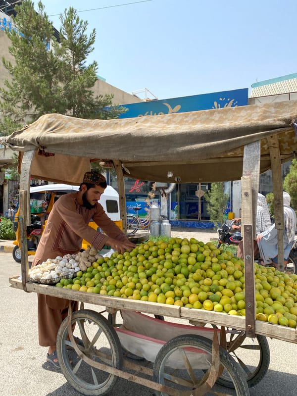 Produce vendors and street life at a Kandahar market