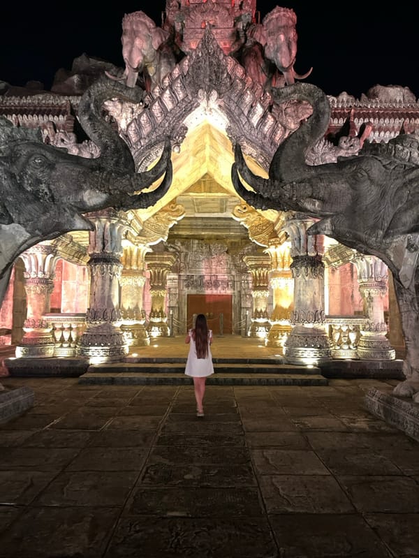 Tourists photograph illuminated temple complex in Kamala, Thailand
