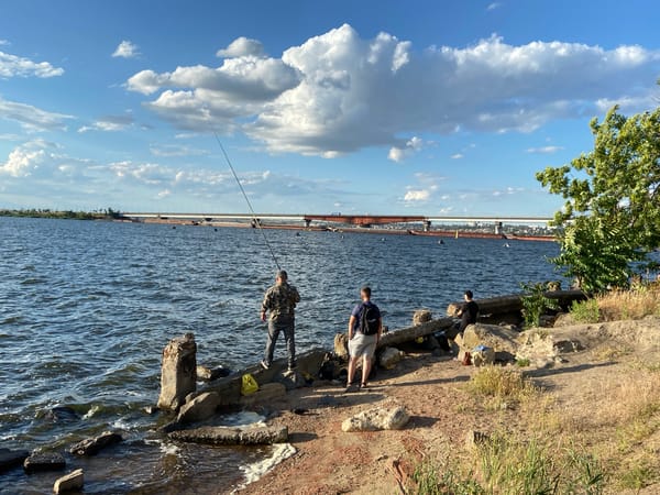 Sunny afternoon at a waterfront — fishing, walking, park views