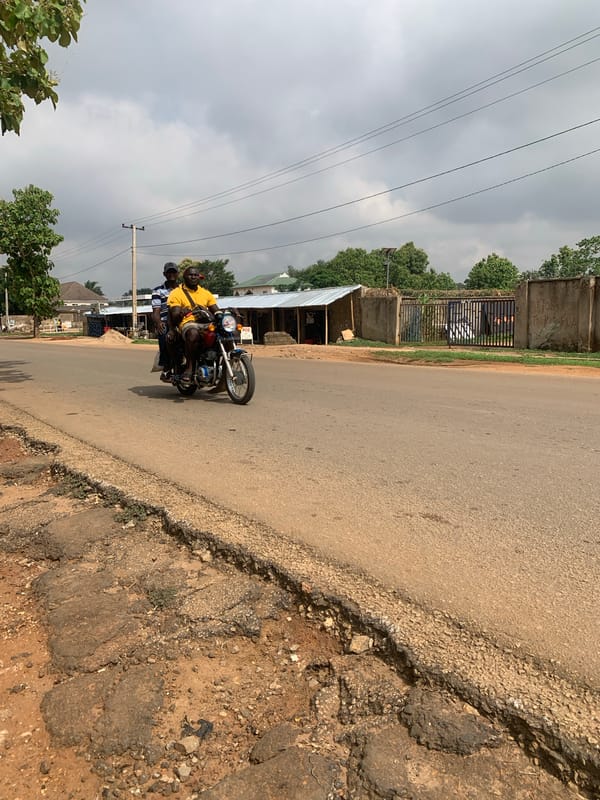 Three men share motorcycle ride in Maigizo, Nigeria