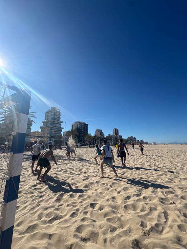 Beachgoer relaxes on crowded Gandia beach during sunny afternoon