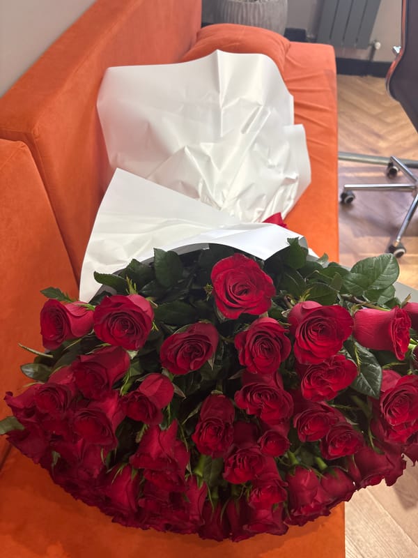 Big red rose bouquet on an orange couch in Astana