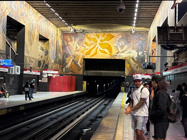 Evening commuters gather at mural-decorated Santiago metro station
