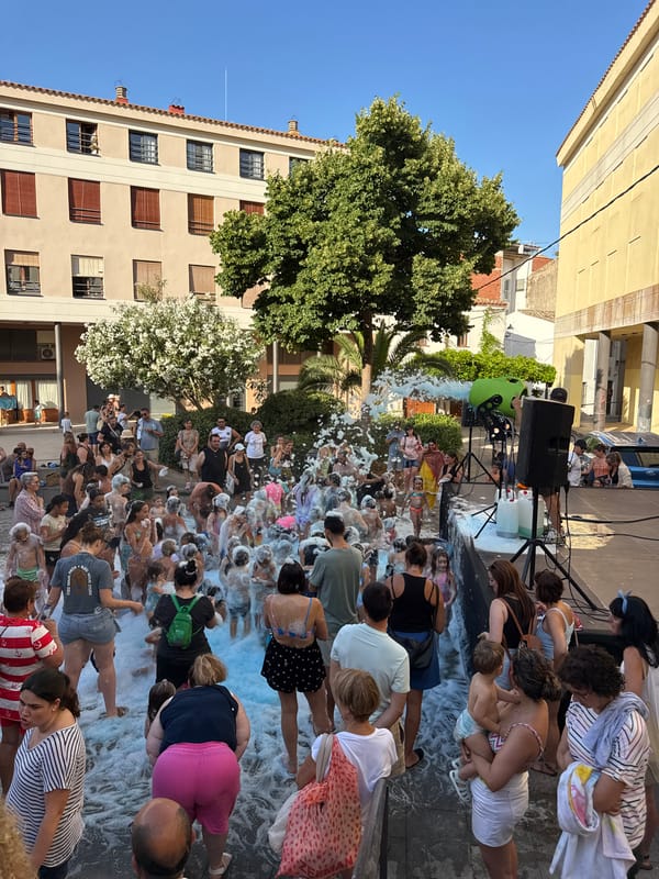 Foam party and street life in Tossa de Mar on a summer afternoon