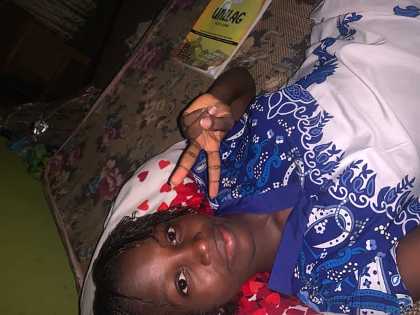 Young person photographed making peace sign indoors in Lagos