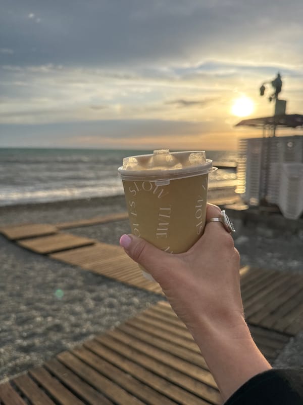 Visitor documents "SLOW TIME" coffee cup moments during Sochi sunset
