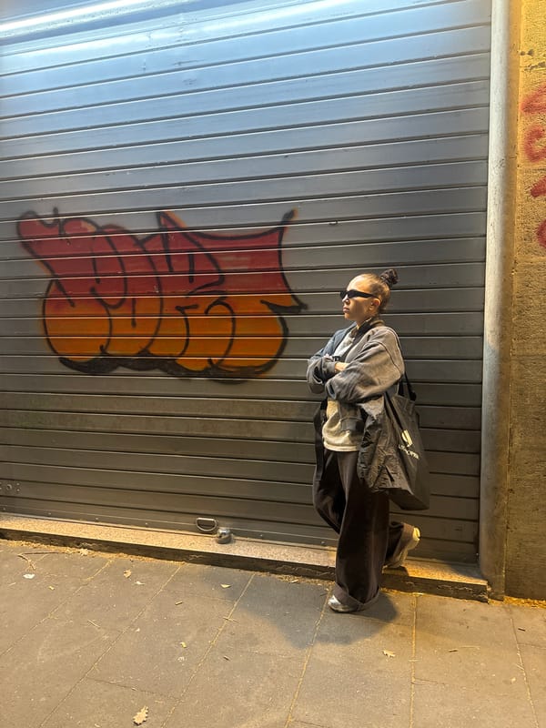 Woman poses by graffitied storefront in Rome