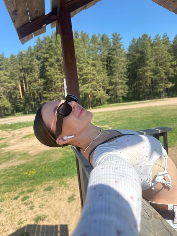 Woman rests at wooden structure in Votkinsk forest area