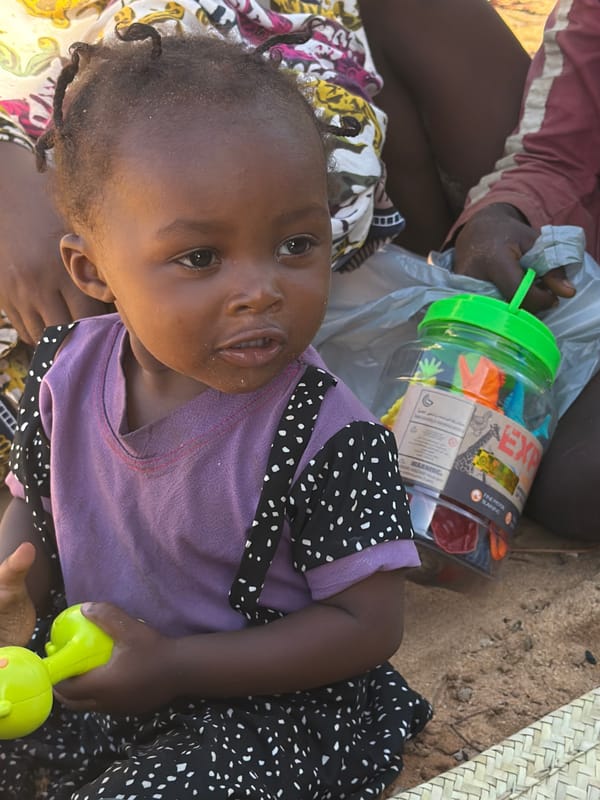 Child with green object photographed in Pemba, Mozambique