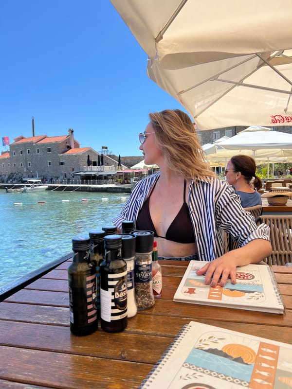 Tourist enjoys sunny afternoon dining and beachwalking in Petrovac