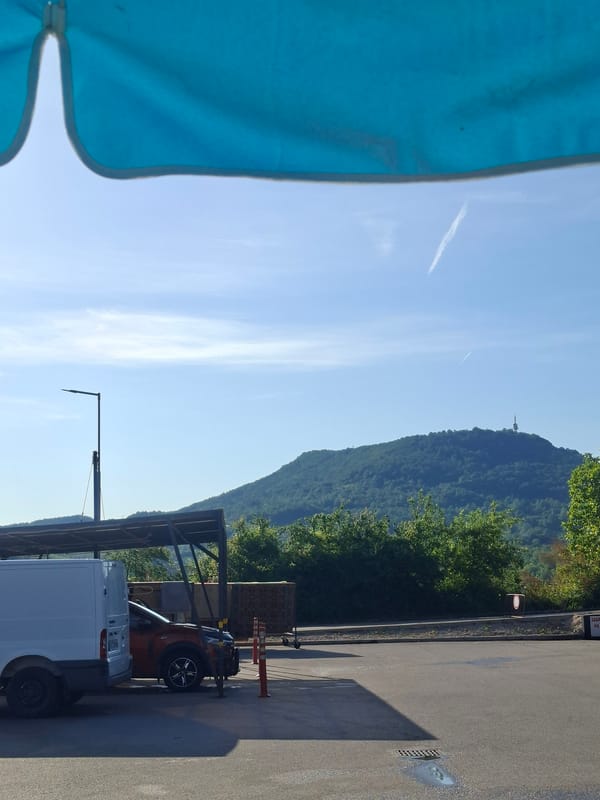 Mountain landscape with blue umbrella observed under clear skies