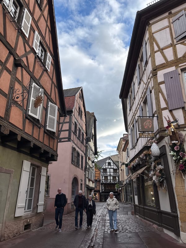 Tourist documents historic Colmar architecture during walking tour