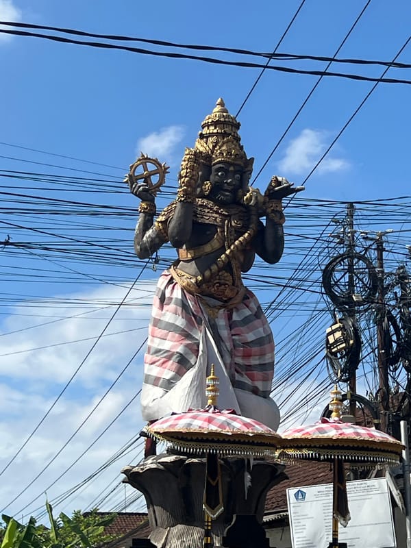 Multi-faced Hindu statue anchors a busy North Kuta intersection