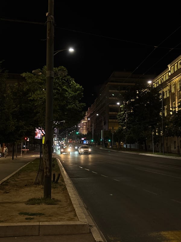 Belgrade streets at night, buses running and people waiting