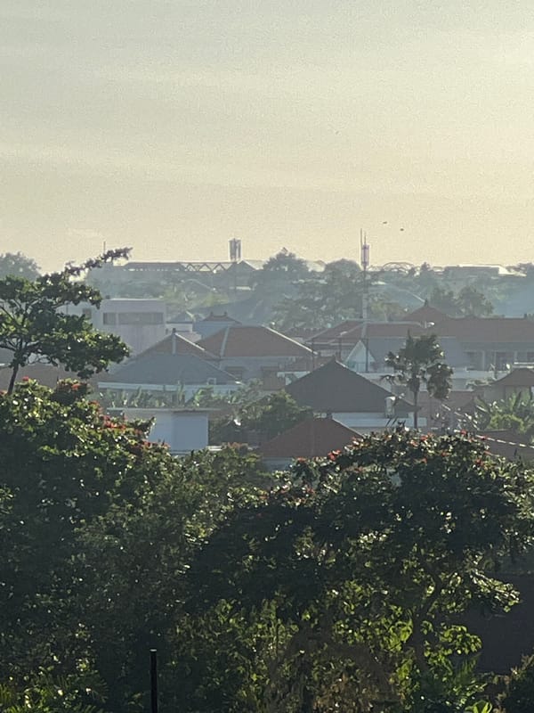 Resident washes scooter in tropical North Kuta morning