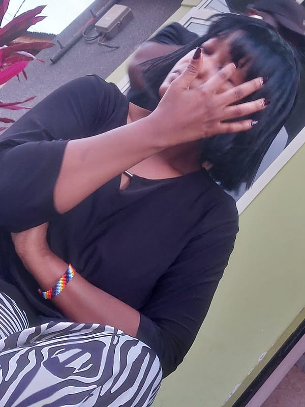 Woman sits outdoors near bath mats in Dar es-Salaam