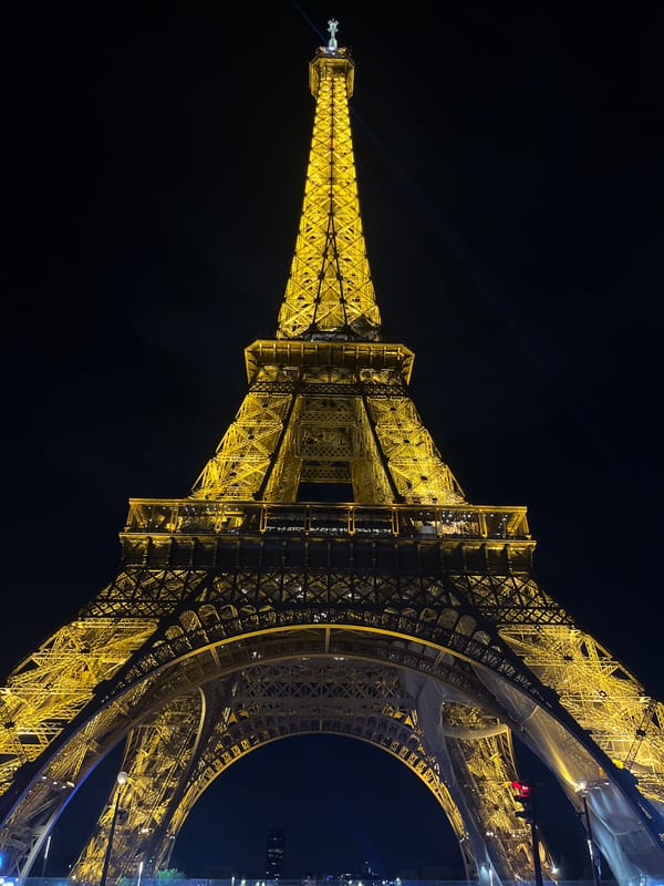 Eiffel Tower displays golden nighttime illumination in Paris