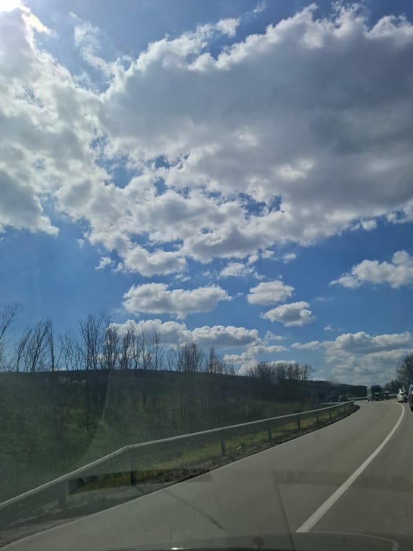 Vehicle travels through Archar, Bulgaria under blue skies