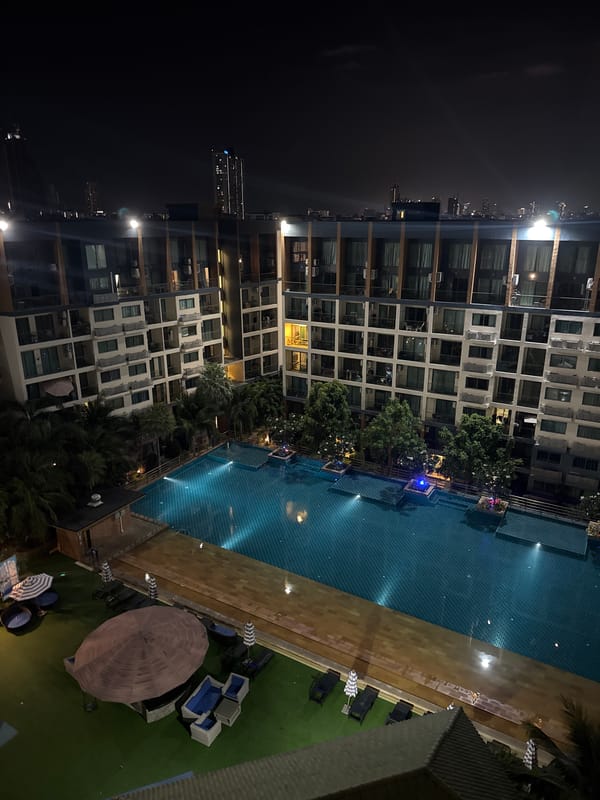 Nighttime aerial view captures lit resort pool in Pattaya