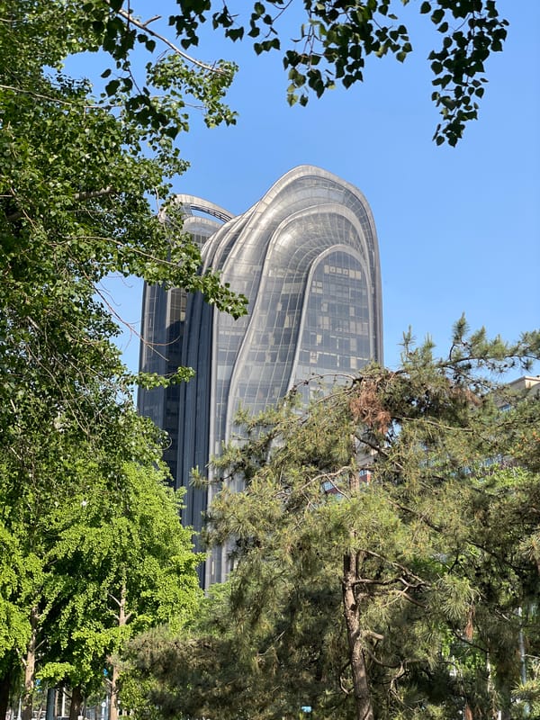 Modern curved-glass building photographed in Beijing's Chaoyang District